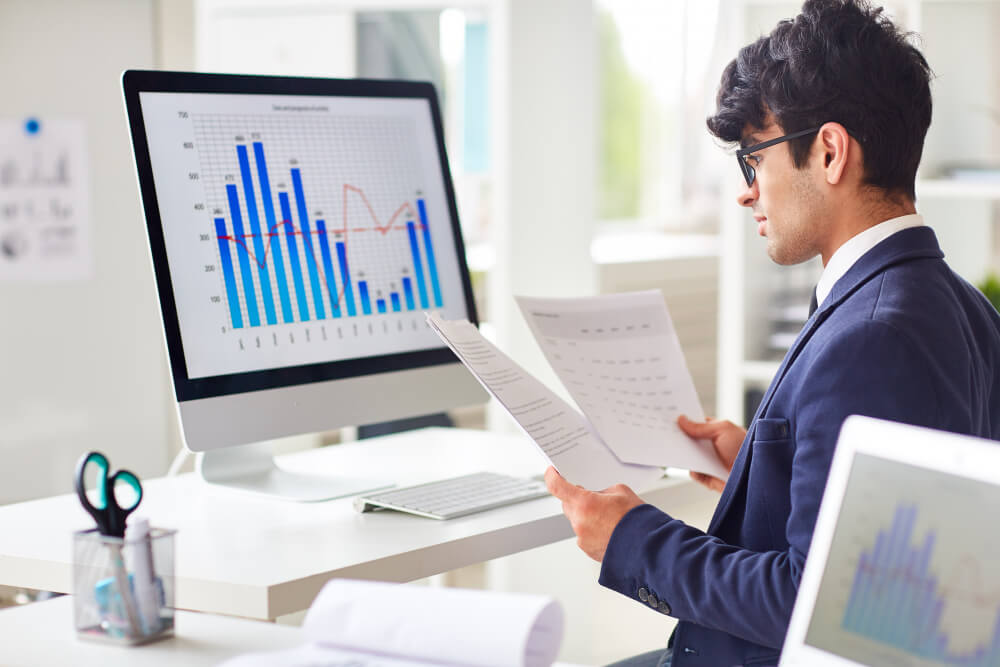 Financial analyst reviewing market data costs and investment reports